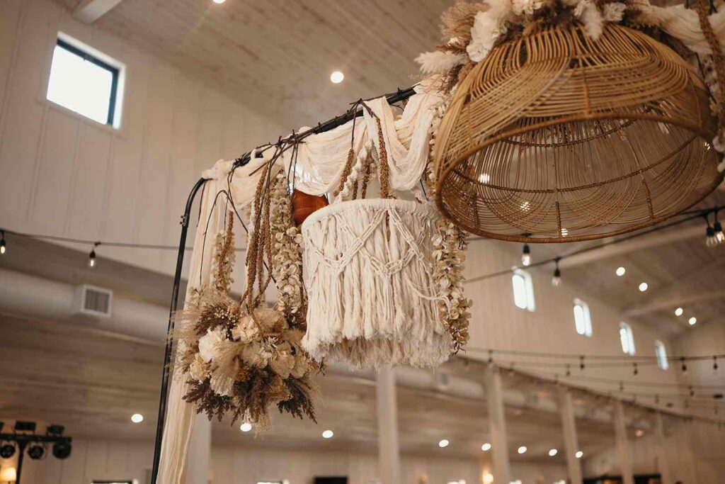 Bohemian wedding hanging decor featuring macrame, dried floral arrangements, and rattan baskets suspended elegantly.
