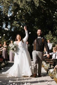Bride and groom walking joyfully during their wedding recessional at The Pines.