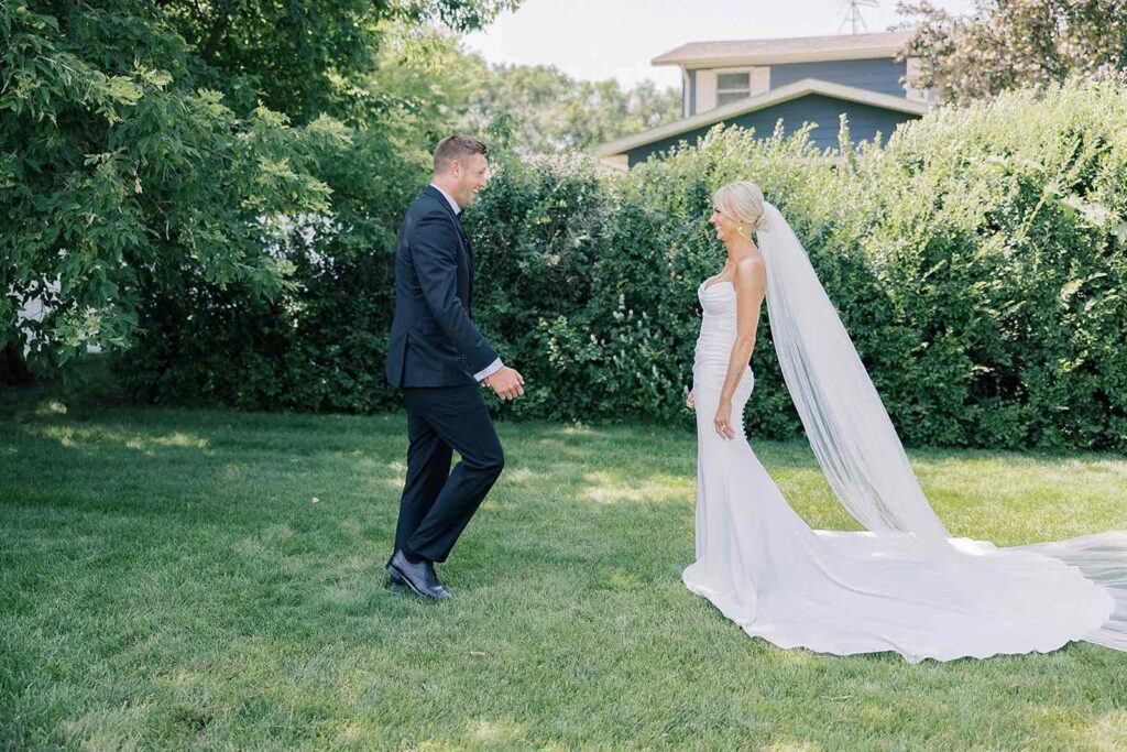 Bride and groom sharing an intimate first look outdoors at The Pines, with natural light and lush greenery surrounding them.