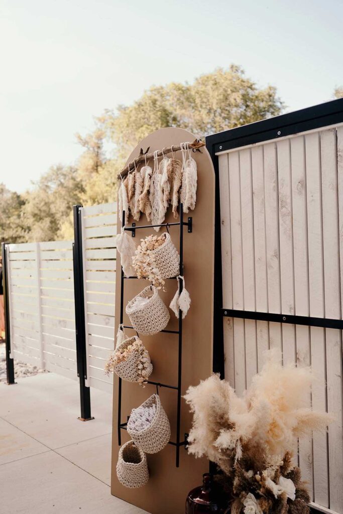 A boho-inspired seating area with a rattan shelf and macramé accents, featuring dried floral arrangements and a warm, rustic aesthetic.