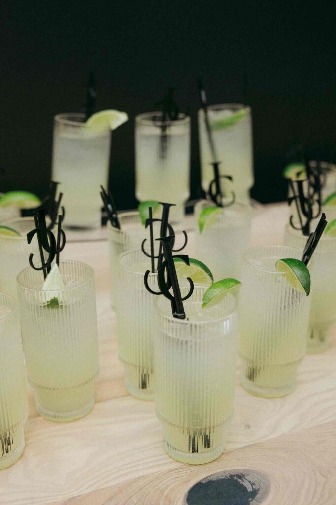 Custom lime cocktails served at a wedding reception at The Pines, featuring personalized initial stir sticks for a unique touch.