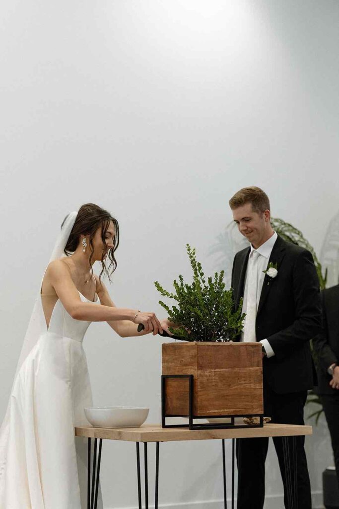 Couple participating in a planting ceremony as part of their wedding tradition at The Pines.