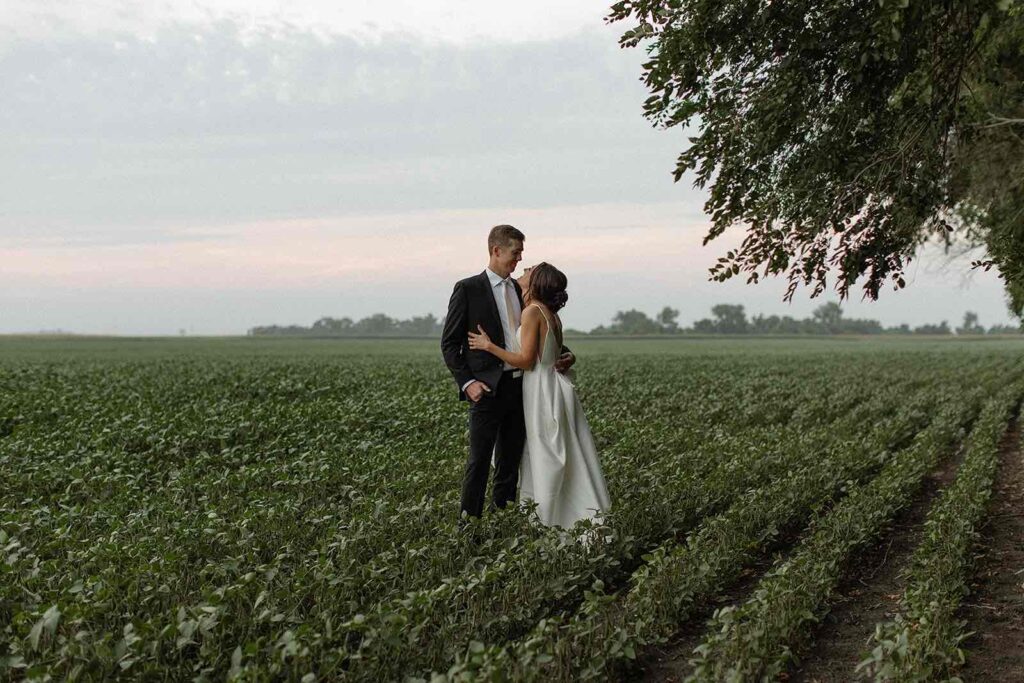 Romantic couple portrait at sunset in a lush field at The Pines Weddings & Events
