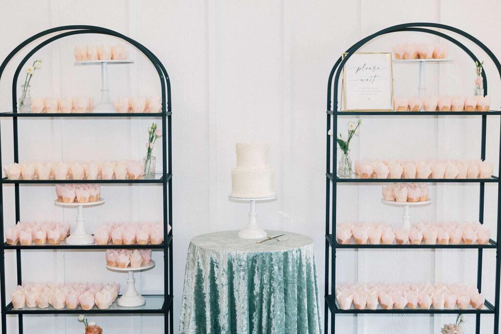 Bridesmaids in matching sage satin pajamas react with excitement as the bride reveals her wedding gown in The Pines' bridal suite.
