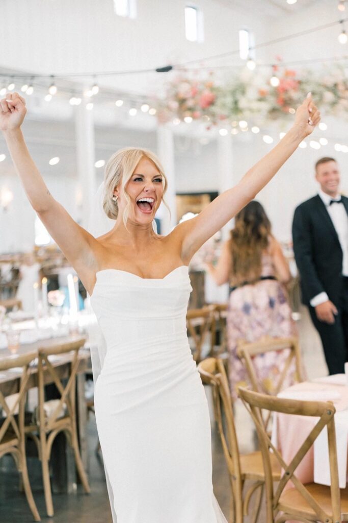 Smiling groom adjusting his bowtie before the wedding ceremony at The Pines.