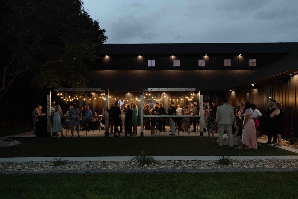 Guests mingling during an outdoor social hour on the patio at The Pines Weddings & Events