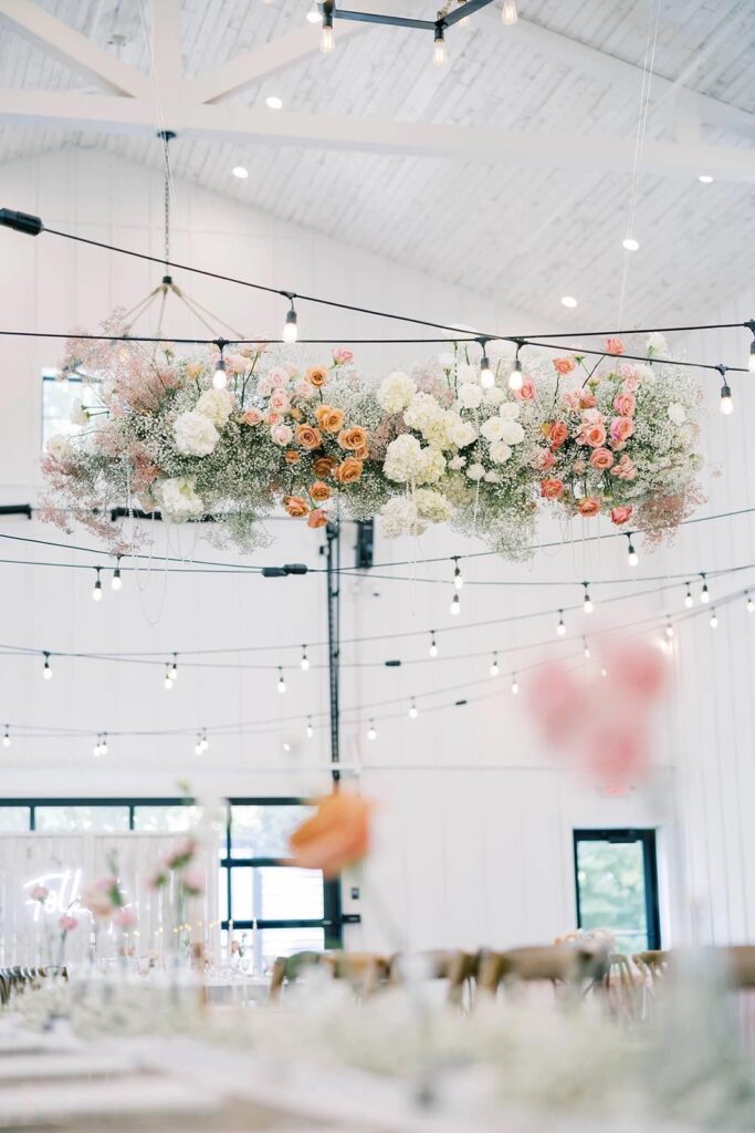 A close-up view of an intricate floral installation with lush roses and baby's breath, accentuating The Pines' reception space.