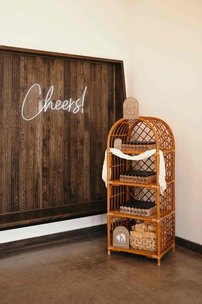 Wedding reception welcome station with wedding favors for the guests to take home on a boho shelf.