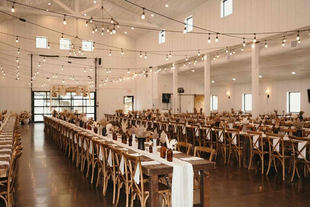 Wedding reception space at Pines White with a boho designs with white table runners and rustic table designs.