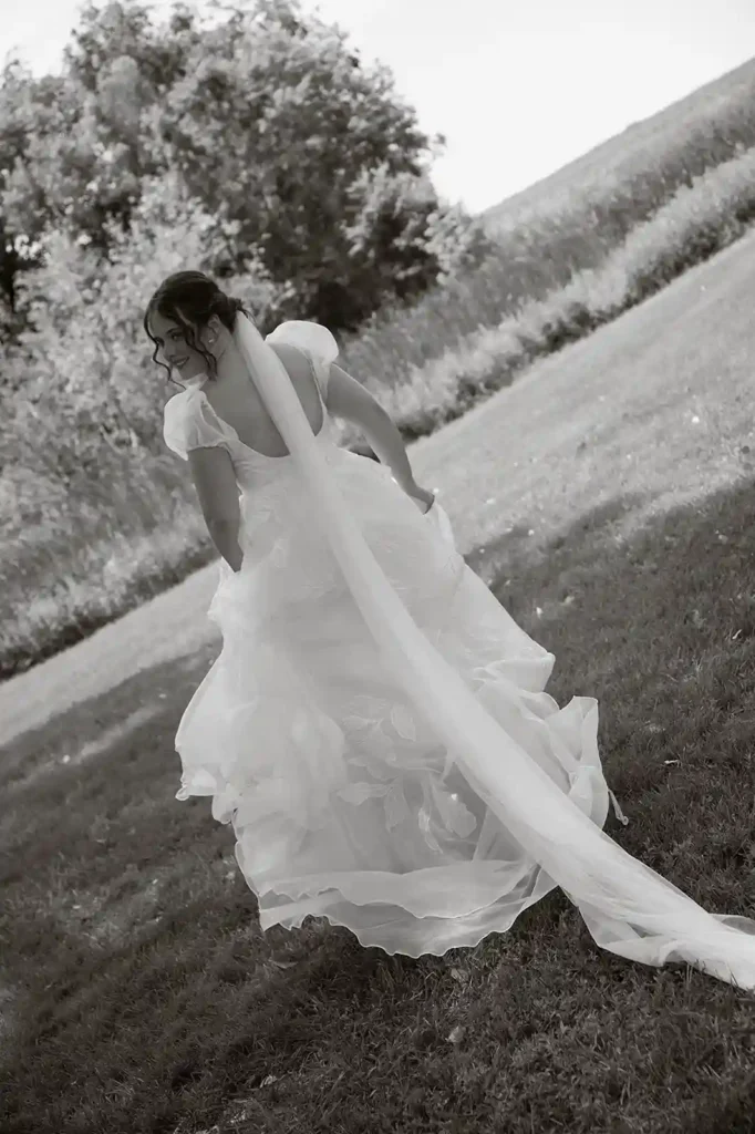 Bride twirls in a floral-detailed gown with a long veil